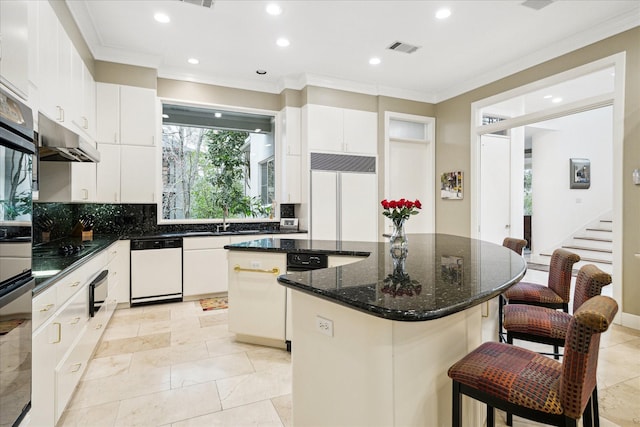 kitchen with ornamental molding, white cabinets, a kitchen island, and black appliances