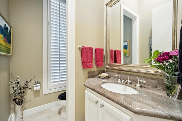 bathroom with baseboards, vanity, toilet, and tile patterned floors