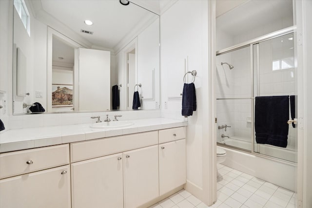 bathroom featuring visible vents, toilet, combined bath / shower with glass door, vanity, and tile patterned floors