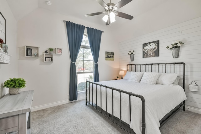 bedroom with light colored carpet, ceiling fan, wooden walls, and baseboards