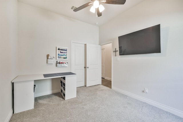 unfurnished office featuring baseboards, a ceiling fan, visible vents, and light colored carpet