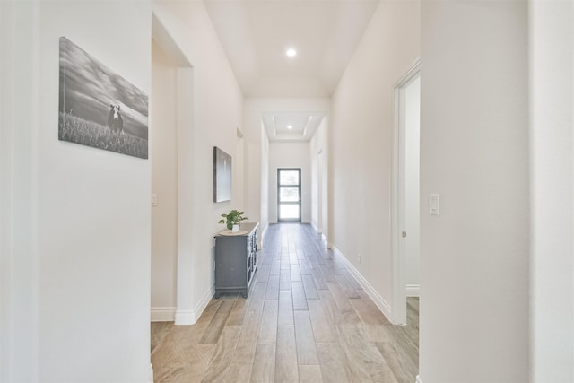 hall featuring recessed lighting, light wood-type flooring, and baseboards