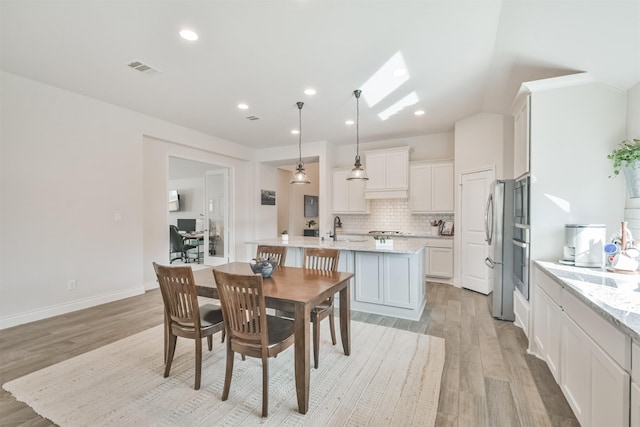 dining space featuring light wood-type flooring, baseboards, visible vents, and recessed lighting