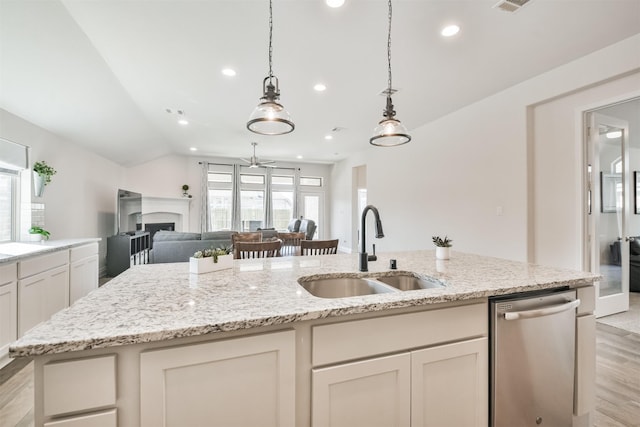 kitchen featuring a fireplace, a sink, open floor plan, dishwasher, and a center island with sink