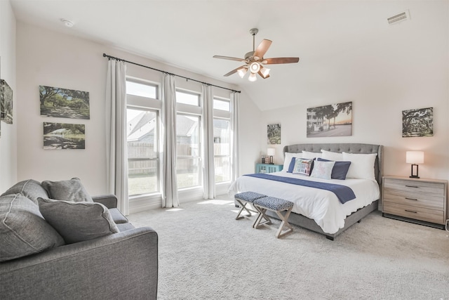 bedroom featuring lofted ceiling, ceiling fan, visible vents, and light colored carpet