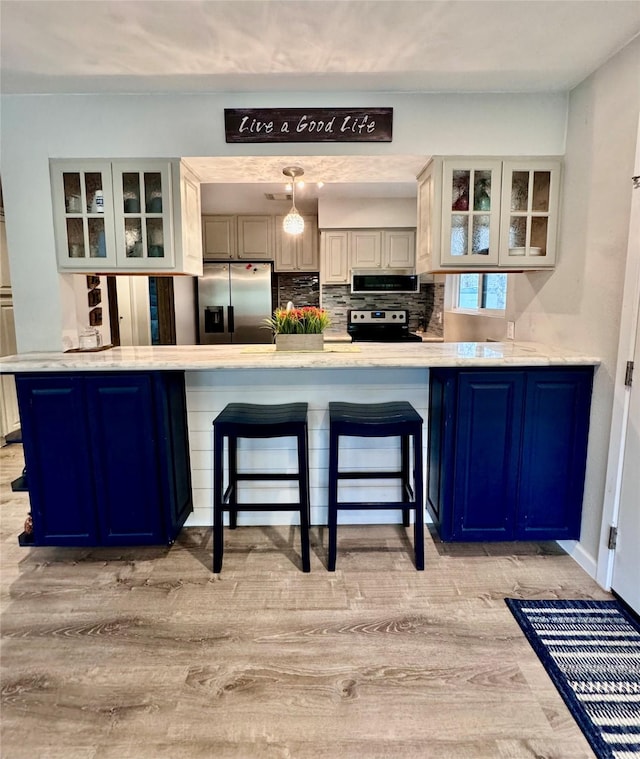 kitchen with light countertops, a peninsula, and glass insert cabinets