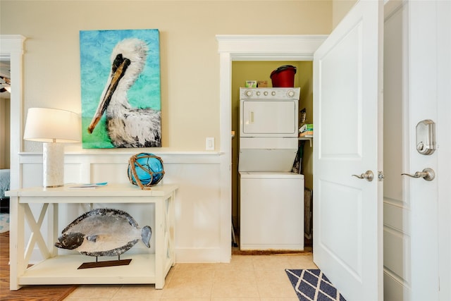 laundry room featuring laundry area, light tile patterned floors, and stacked washer / drying machine