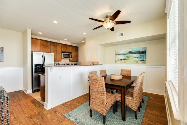 dining area featuring a wainscoted wall, light wood finished floors, visible vents, and recessed lighting