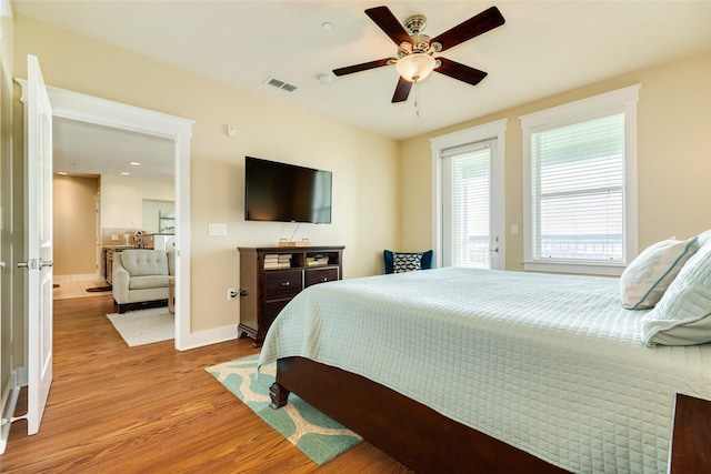 bedroom with baseboards, visible vents, a ceiling fan, access to exterior, and light wood-style floors