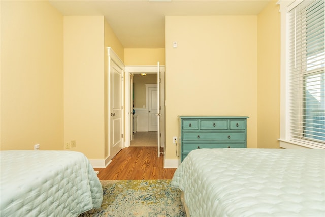 bedroom with light wood finished floors and baseboards