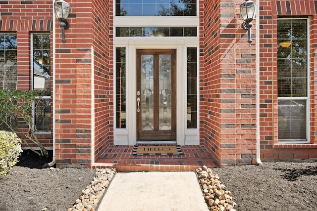 entrance to property featuring french doors and brick siding