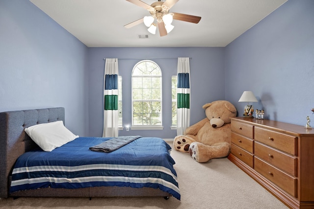 carpeted bedroom featuring visible vents and a ceiling fan