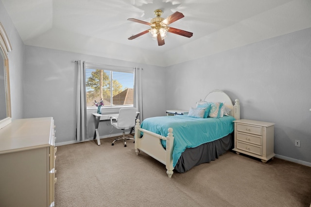 bedroom featuring a raised ceiling, light colored carpet, ceiling fan, and baseboards