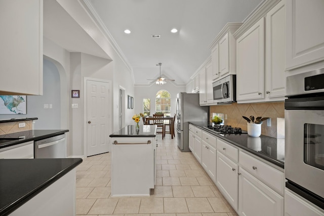 kitchen featuring dark countertops, white cabinetry, appliances with stainless steel finishes, and arched walkways