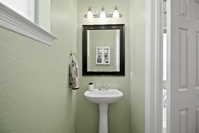 bathroom featuring a sink and a textured wall