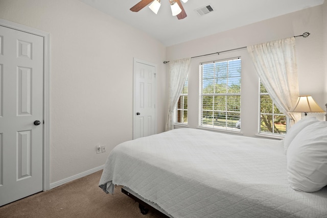 carpeted bedroom featuring a ceiling fan, visible vents, vaulted ceiling, and baseboards