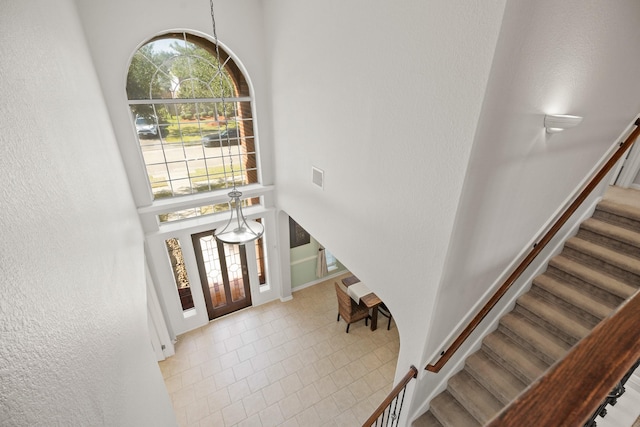 foyer entrance with visible vents, a high ceiling, stairway, and a wealth of natural light