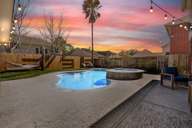 view of swimming pool with a fenced backyard, a pool with connected hot tub, and a patio