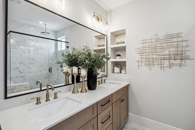 bathroom with a marble finish shower, a sink, marble finish floor, and double vanity