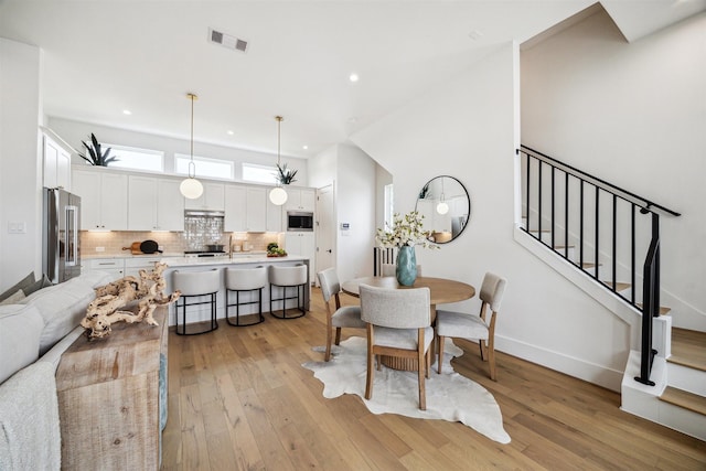 dining area featuring stairway, light wood-type flooring, baseboards, visible vents, and recessed lighting