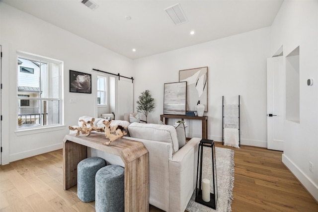 living area featuring baseboards, visible vents, and light wood-type flooring