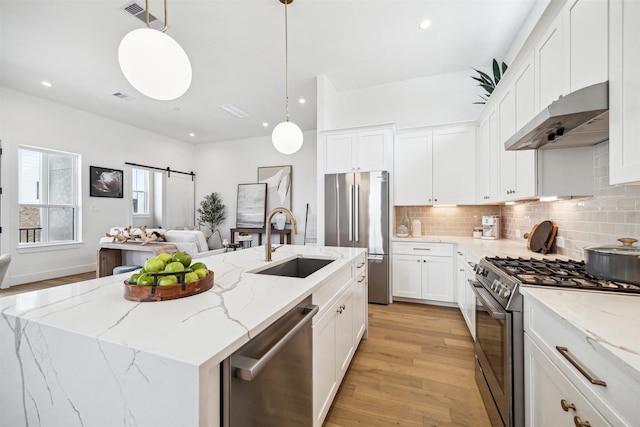 kitchen featuring a sink, light wood-style floors, appliances with stainless steel finishes, under cabinet range hood, and visible vents