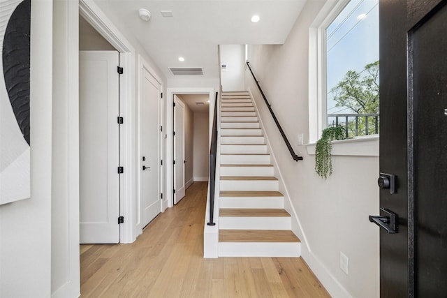 stairs featuring baseboards, wood finished floors, visible vents, and recessed lighting