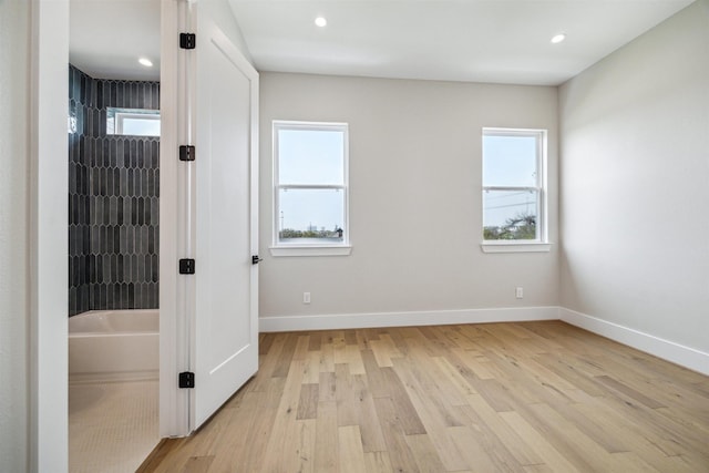 unfurnished bedroom with recessed lighting, light wood-type flooring, baseboards, and multiple windows
