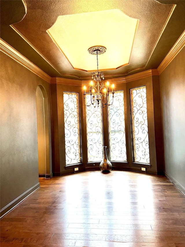 18931 Winding Atwood Ln, Tomball, TX 77377 - empty room with arched walkways, ornamental molding, a raised ceiling, and hardwood / wood-style flooring