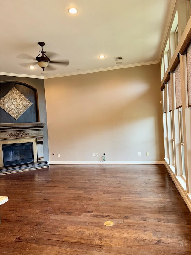 18931 Winding Atwood Ln, Tomball, TX 77377 - unfurnished living room with baseboards, visible vents, a glass covered fireplace, wood finished floors, and crown molding