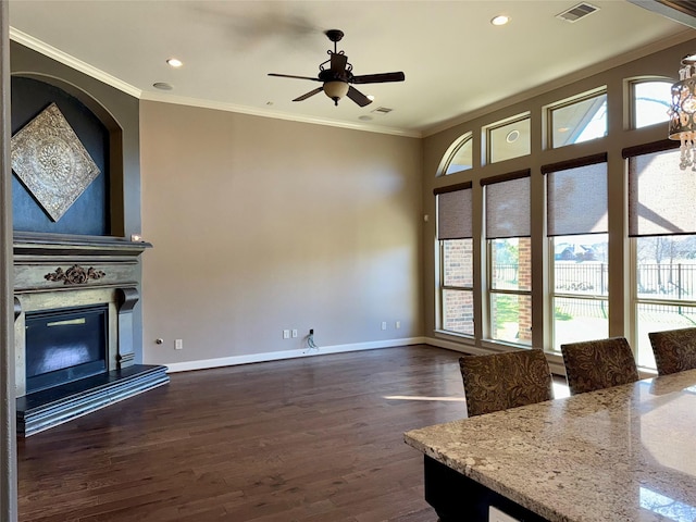 18931 Winding Atwood Ln, Tomball, TX 77377 - unfurnished living room with dark wood-type flooring, visible vents, baseboards, a glass covered fireplace, and crown molding