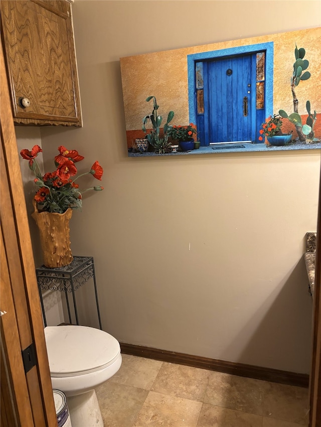 bathroom with toilet and baseboards