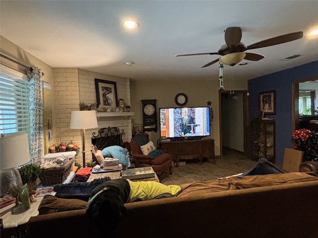 carpeted living area with ceiling fan, a fireplace, visible vents, and recessed lighting