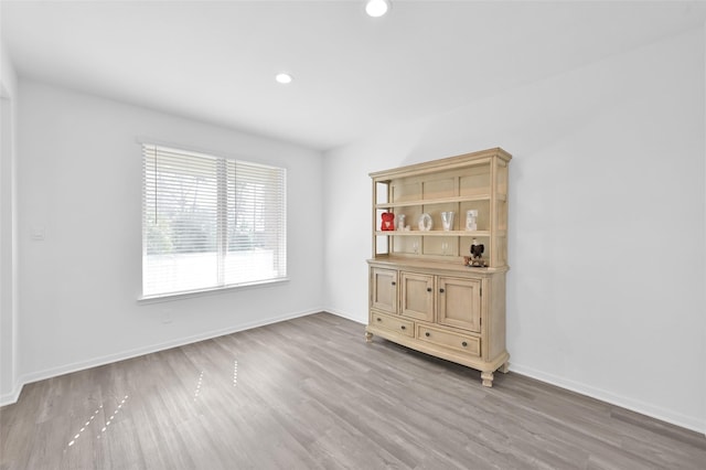 empty room with recessed lighting, wood finished floors, and baseboards