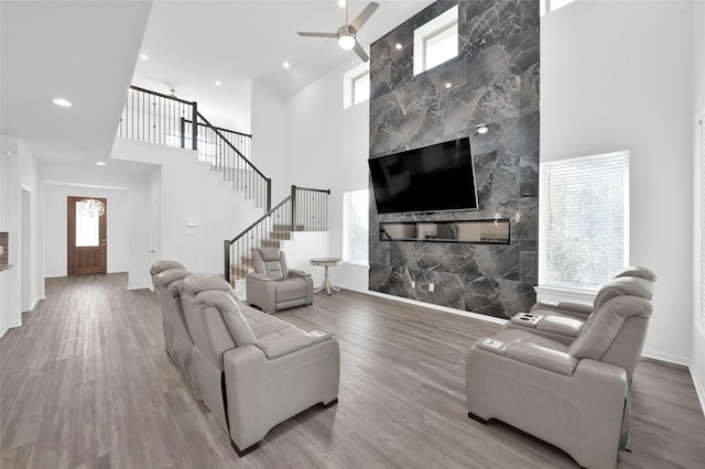 living room featuring a high ceiling, stairway, wood finished floors, and recessed lighting