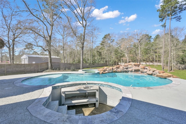 view of swimming pool featuring a patio area, a pool with connected hot tub, and a fenced backyard