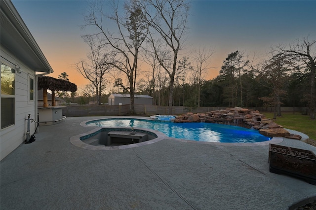 view of pool with a fenced backyard, a pool with connected hot tub, and a patio