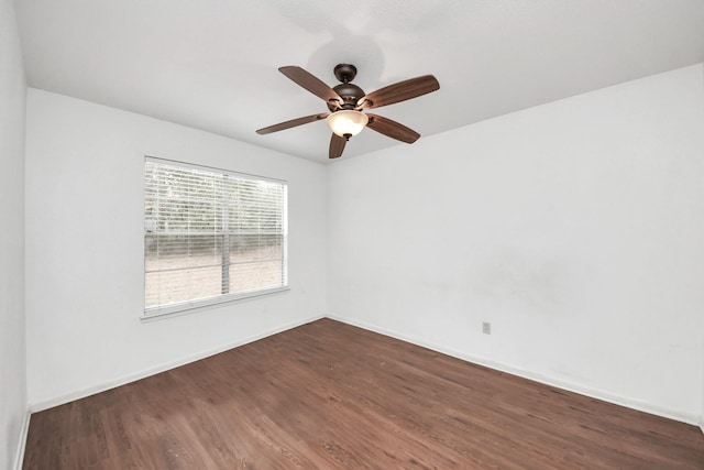 empty room featuring dark wood-style floors, ceiling fan, and baseboards