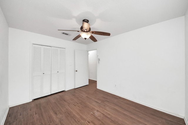 unfurnished bedroom with baseboards, a closet, visible vents, and wood finished floors