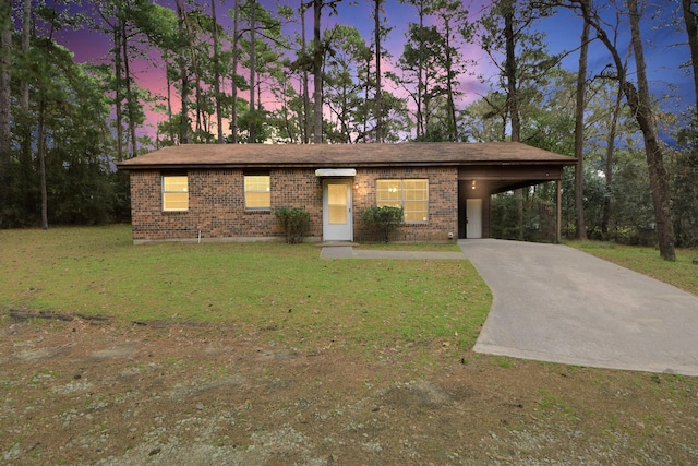 view of front of house featuring brick siding, driveway, and a front lawn