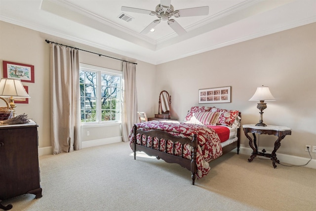 bedroom featuring ornamental molding, a tray ceiling, light carpet, and visible vents