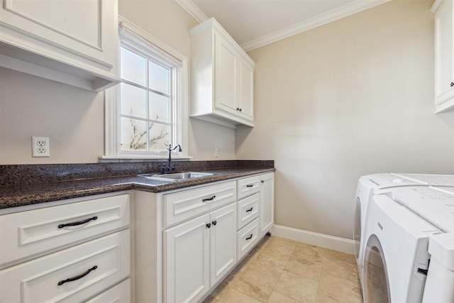 laundry area with cabinet space, baseboards, ornamental molding, separate washer and dryer, and a sink