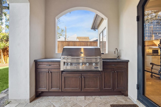 view of patio featuring a sink, grilling area, and an outdoor kitchen