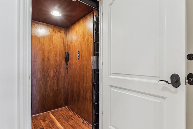 details featuring elevator and wood finished floors