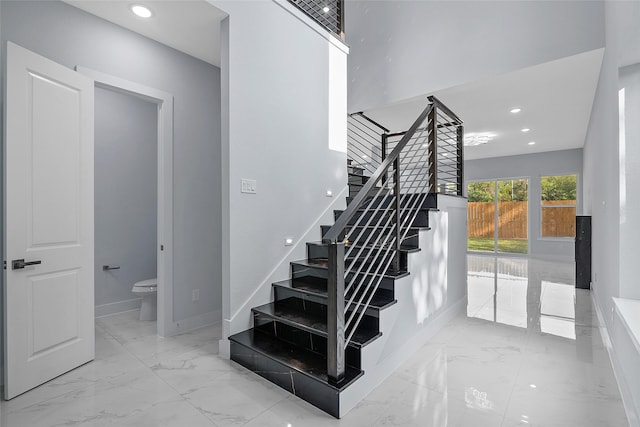 staircase with recessed lighting, marble finish floor, and baseboards