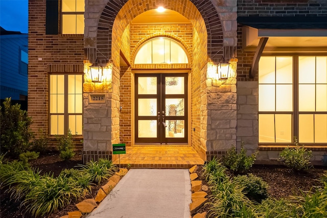 view of exterior entry with french doors and brick siding