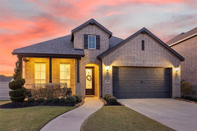 view of front of house with an attached garage, driveway, a shingled roof, and brick siding