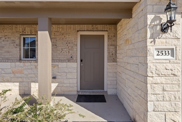 entrance to property with stone siding and brick siding