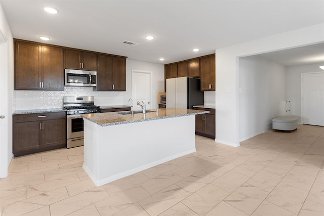 2533 Allegretto Sea Dr, Katy, TX 77493 - kitchen with visible vents, an island with sink, light stone counters, marble finish floor, and stainless steel appliances