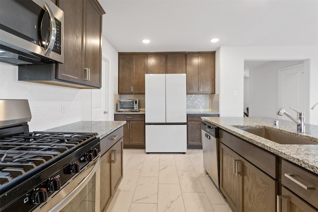 2533 Allegretto Sea Dr, Katy, TX 77493 - kitchen with marble finish floor, recessed lighting, appliances with stainless steel finishes, a sink, and light stone countertops